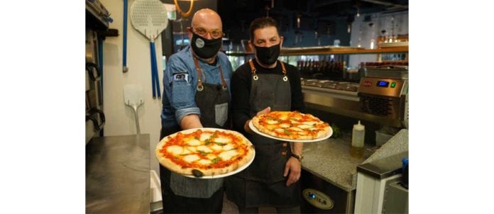 Founders of MAS.E.MO Pizza concept holding fresh pizzas