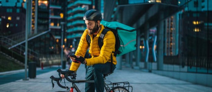 Food delivery courier delivering food to clients on bicycle