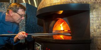 David Binkle cooking a pizza in a stone oven