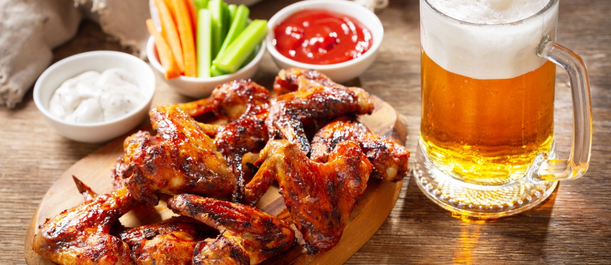 Plate of grilled chicken wings and mug of beer