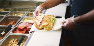 Person preparing sub sandwich in a fast food restaurant