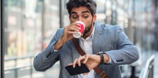 Man running late for work drinking a cup of coffee
