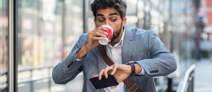 Man running late for work drinking a cup of coffee