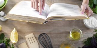 lady reading cookbook recipe in culinary book at home with kitchenware