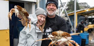 Carmen & Rob smiling together while Rob holds two crabs