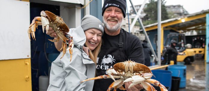 Carmen & Rob smiling together while Rob holds two crabs