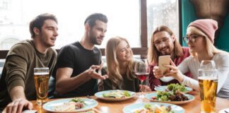 Cheerful friends sitting in cafe talking with each other