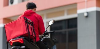 Food courier delivering food to customers by a motorbike