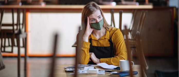 Frustrated owner sitting at table in closed cafe