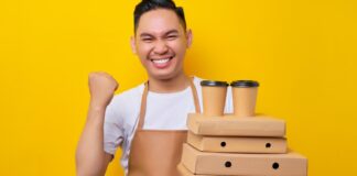 Barista holding pizza boxes and coffee cups