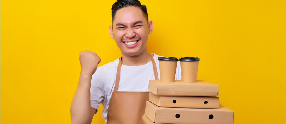 Barista holding pizza boxes and coffee cups