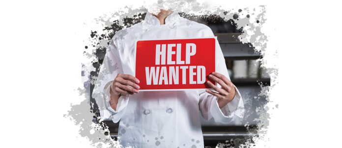 Chef holding a Help Wanted Sign