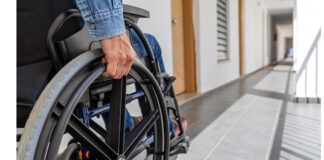 Man holding wheel of his Wheelchair