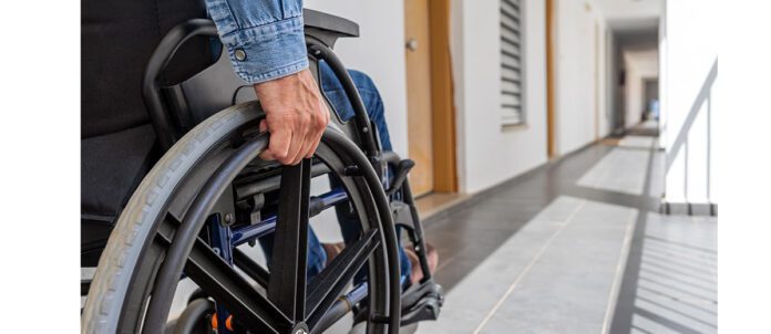 Man holding wheel of his Wheelchair