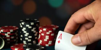 Person holding an ace of diamonds during a game of poker.