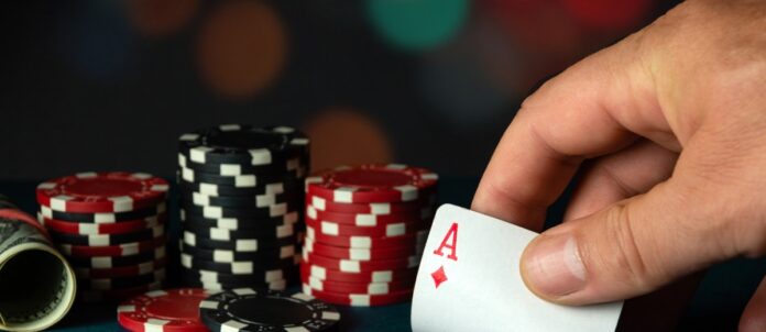 Person holding an ace of diamonds during a game of poker.