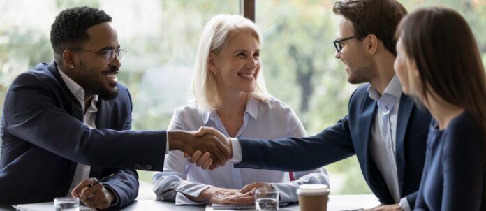 Businesspeople shake hands get acquainted greeting at team meeting in office.