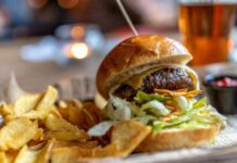 Burger with french fries on the side and a craft beer