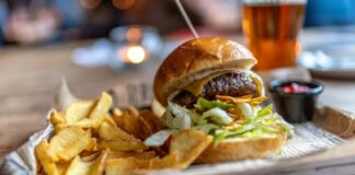 Burger with french fries on the side and a craft beer