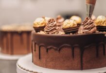Confectioner decorating chocolate cake close-up
