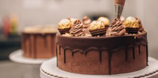 Confectioner decorating chocolate cake close-up