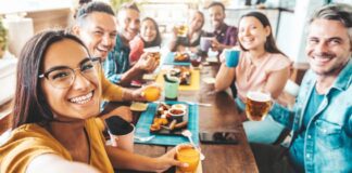 Friends eating outside in patio area at restaurant together