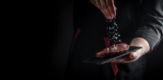 Chef sprinkling salt on a Wagyu beef