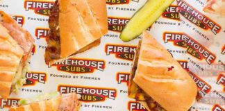 Firehouse Subs on wrapper with sliced pickle beside sandwich