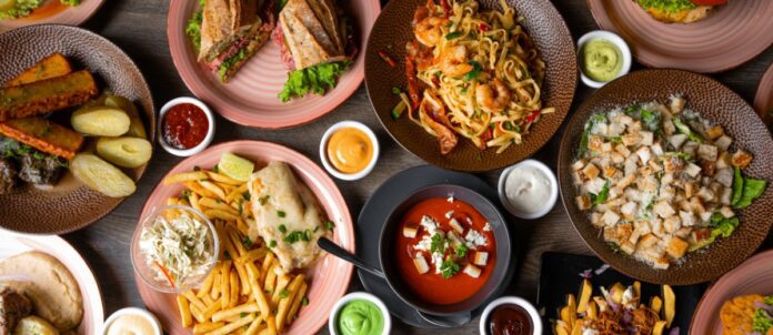 Variety of different food on wooden table in restaurant