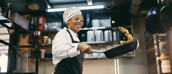 Chef having fun while preparing food in the kitchen at restaurant