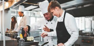 Chef talking with student in kitchen at Hospitality & Tourism School