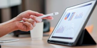 Close up corporate employee pointing at tablet while reading report and analytics