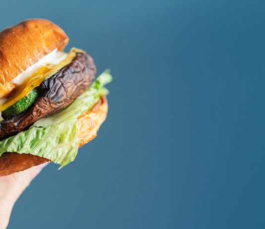 Person's hand hold a vegetarian hamburger