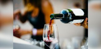 Man pouring red wine to wine glass.