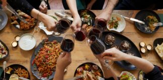 dinner table from above with hands eating drinking and toasting