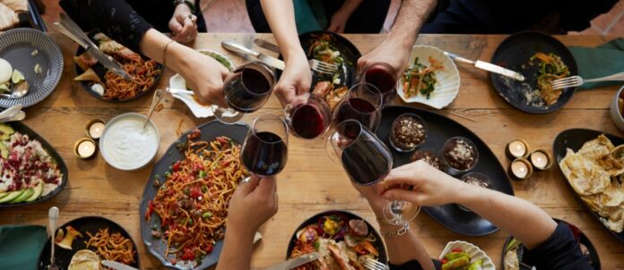 dinner table from above with hands eating drinking and toasting