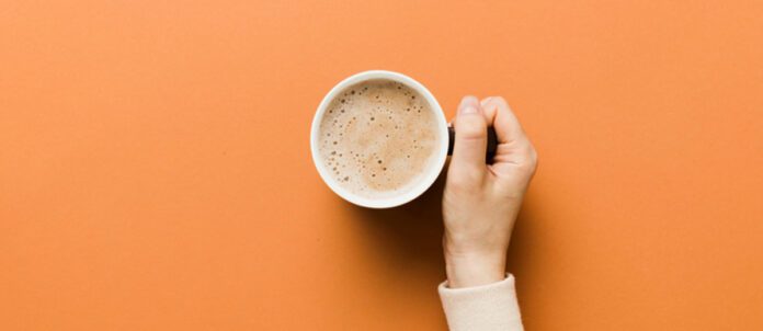 Woman's hand holding a cup of coffee