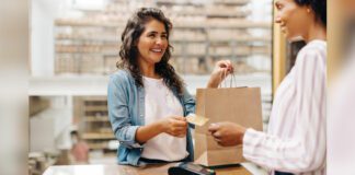 Female customer paying her bill with a credit card in a retail store