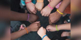Children placing hands together in a circle