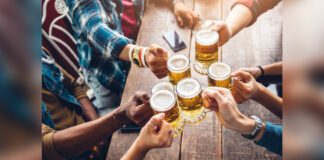 Group of people enjoying and toasting a beer at pub