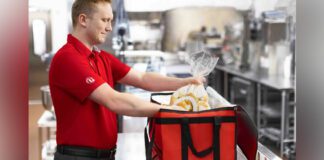 Chick-fil-A employee putting customer's order in a delivery bag