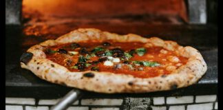 Pizza being taken out of oven
