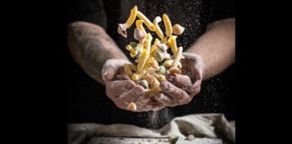 Chef hold an assorted group of pasta covered in flour