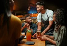 Waiter serving alcoholic beverages at restaurant