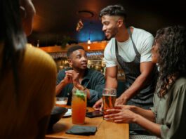 Waiter serving alcoholic beverages at restaurant