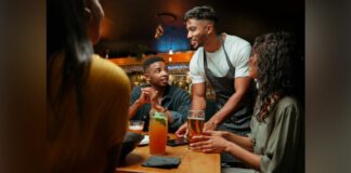 Waiter serving alcoholic beverages at restaurant