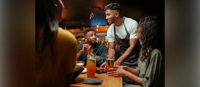 Waiter serving alcoholic beverages at restaurant