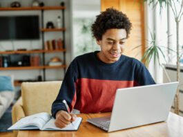 Young man attending a online distance learning class
