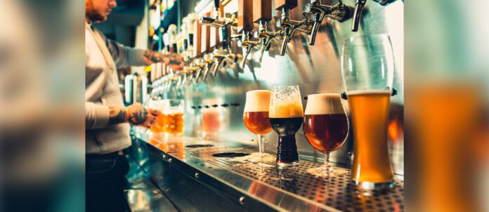Hand of bartender pouring a large lager beer in tap