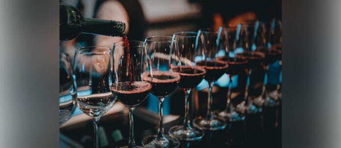 A sommelier pouring a bottle of red wine
